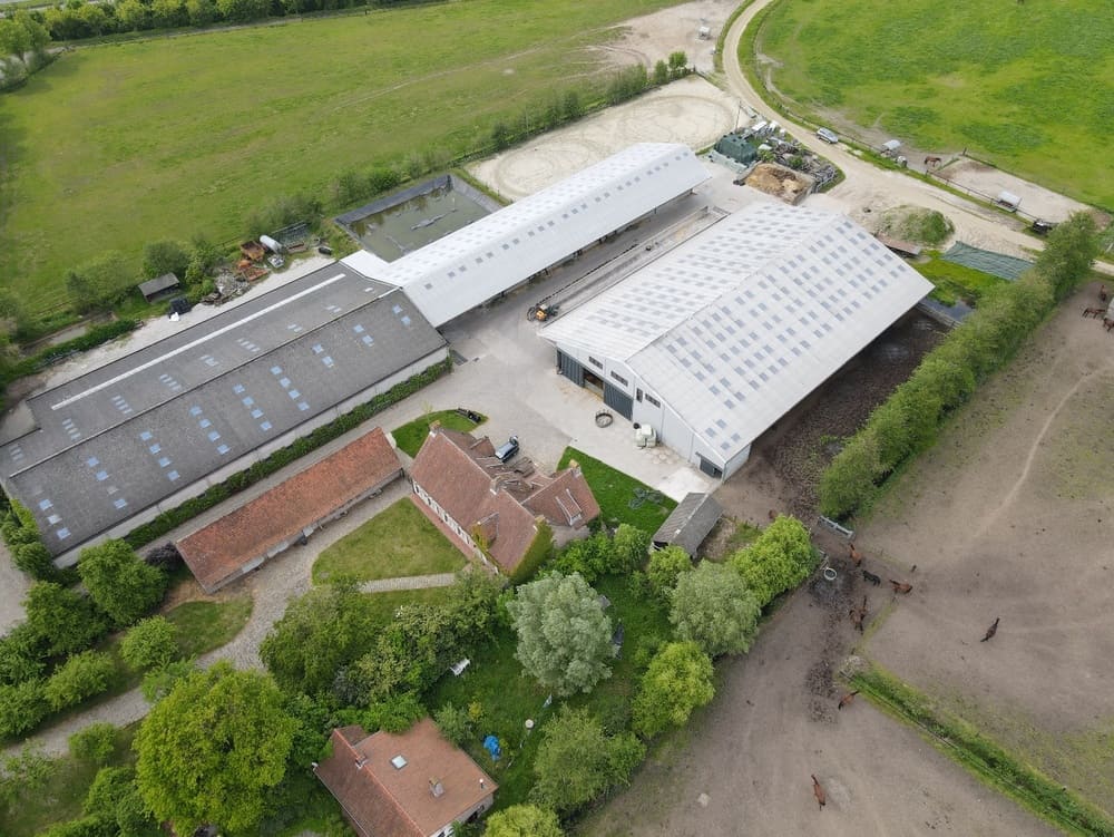 Aerial view of a farm with a barn and stables.